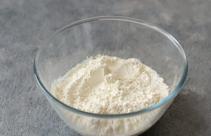 1. Этап. Беляши с грибами: Просейте в миску муку и соль. Начните постепенно замешивать тесто.