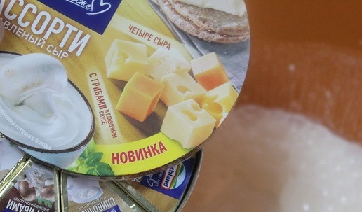 1. Этап. Картофельный гратен с сыром и беконом: Сыр развернуть, выложить к сливкам, нарезая маленькими кусочками, и хорошо перемешать венчиком.