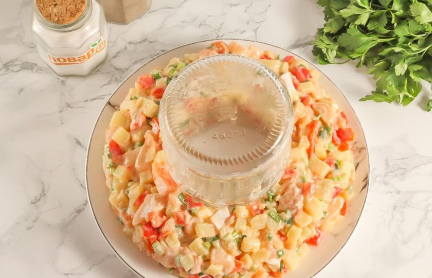 1. Этап. Салат Русские традиции с красной рыбой: Поместите на середину тарелки небольшую банку и вокруг нее аккуратно выложите салат в виде кольца. Банку извлеките.