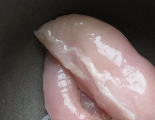 1. Этап. Сочные куриные котлеты из грудки: 1. Перед тем как приготовить сочные куриные котлеты из грудки, помойте и обсушите бумажным полотенцем куриную грудку от излишней влаги. Филе срежьте с кости.