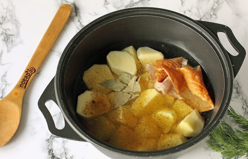 1. Этап. Тушеная картошка с копченой курицей: Добавьте к картофелю специи, лавровый лист и копченую куриную кожу (для аппетитного аромата). Залейте картофель водой, чтобы она почти полностью покрывала его и поставьте тушиться на средний огонь.