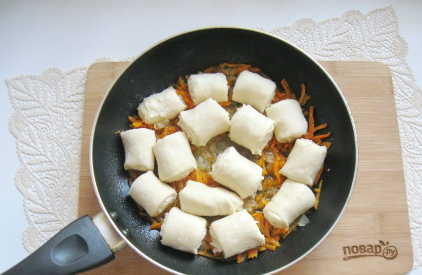 1. Этап. Бешбармак по-нанайски: Рулеты выложите в сковороду с луком и морковью.