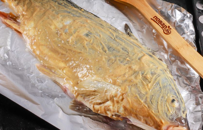 1. Этап. Карп в горчице в духовке: Натрите карпа с двух сторон и внутри горчицей. Используйте обычную магазинную горчицу, но не зерновую, так как зерна при запекании обуглятся и подгорят.