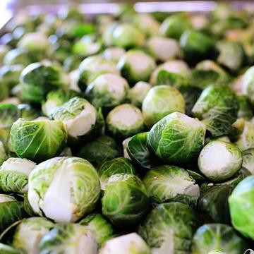 1. Этап. Брюссельская капуста с бальзамическим уксусом и клюквой: 1. Промыть и высушить брюссельскую капусту. Разрезать пополам при желании, также вы можете использовать капусту целиком. Выложить брюссельскую капусту на два противня и перемешать с оливковым маслом. Посыпать большим количеством соли и черного перца.