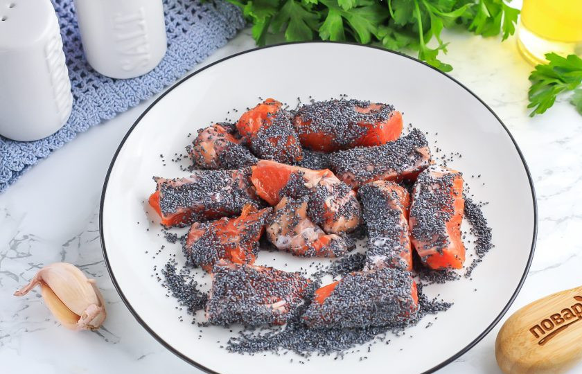 1. Этап. Жареный лосось с маком: Высыпьте сушеный мак на тарелку и обпанируйте в нем кусочки лосося со всех сторон.