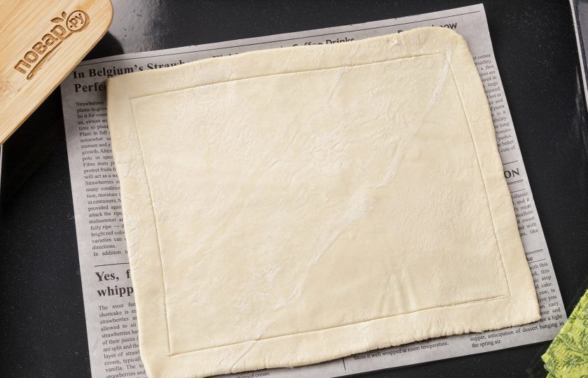 1. Этап. Пирог с грушей из бездрожжевого теста: Тесто раскатайте в прямоугольник или квадрат на поверхности, присыпанной мукой. Выложите на противень с пергаментом. Отступив от края 1-1,5 см., сделайте ножом неглубокие надрезы.