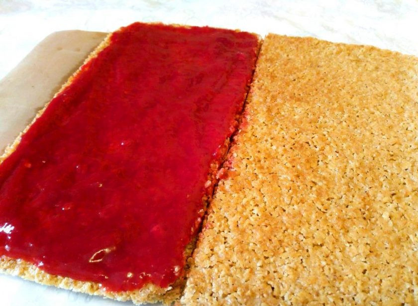 1. Этап. Геркулесовые пирожные: Смажьте джемом половину выпеченной основы, а затем аккуратно разрежьте острым ножом на 2 равных части.