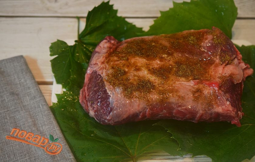 1. Этап. Баранья лопатка в соляной корочке: 1. Мясо помойте, выложите на виноградные листья и посыпьте аджикой.