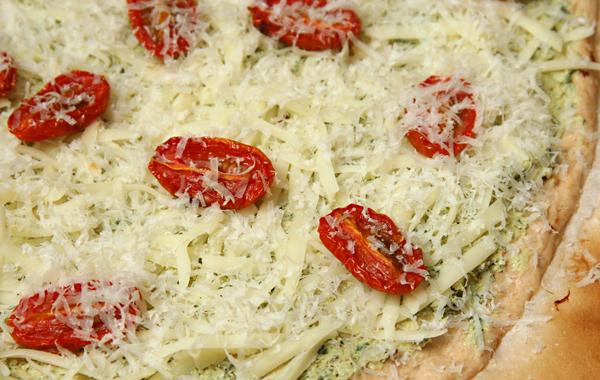 1. Этап. Пицца с ветчиной, козьим сыром и помидорами: 3. Посыпать тертым сыром Моцарелла, выложить помидоры и посыпать тертым Пармезаном. Выложить пиццу на камень для пиццы вместе с пергаментной бумагой. Выпекать 8-10 минут, пока корочка не потемнеет по краям.