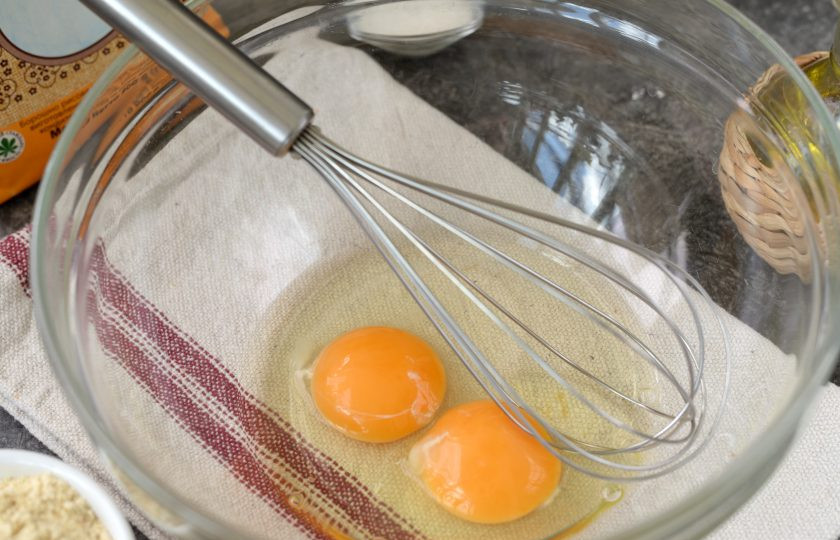 1. Этап. Блины без пшеничной муки: В глубокую миску вбейте два небольших яйца, взбейте их венчиком в пену.