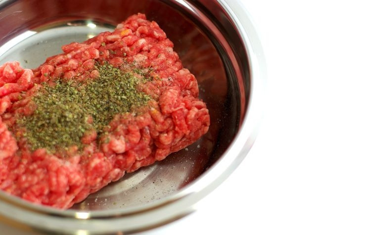 1. Этап. Домашние пельмени: Фарш выкладываем в удобную посуду. Добавляем соль, перец, майоран, три ложки молока и хорошенько замешиваем.