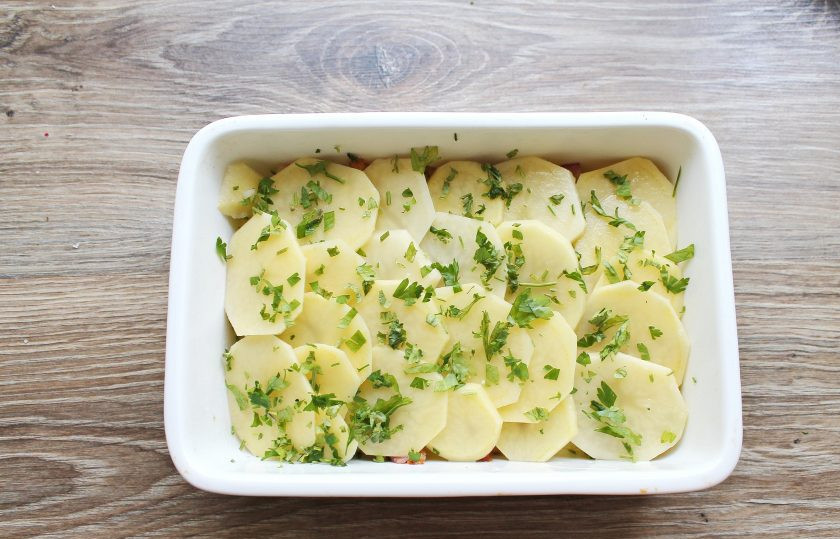 1. Этап. Гратен с беконом: Снова выложите слой картофеля и посыпьте петрушкой.