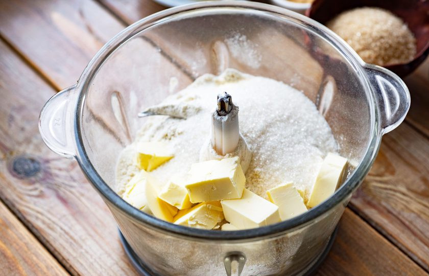 1. Этап. Тыквенный пирог Гарри Поттера: Займитесь приготовлениям теста. В чашу блендера или чоппера выложите муку, холодное масло нарезанное кусочками и белый сахар.