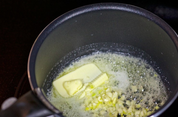 1. Этап. Ракушки с курицей и грибами: В глубокий сотейник сложите сливочное масло, мелко нарубленный чеснок. Протомите несколько минут.