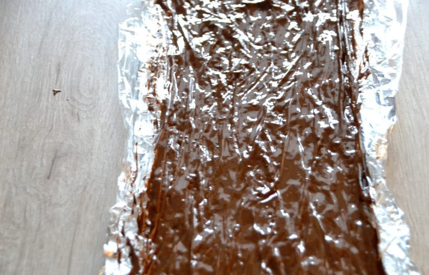 1. Этап. Торт Полено с вишней: Растопите на водяной бане или в микроволновой печи короткими импульсами шоколад, кулинарной кистью размажьте этот шоколад на подготовленную фольгу с пленкой, поместите на холод минут на 20 для застывания.