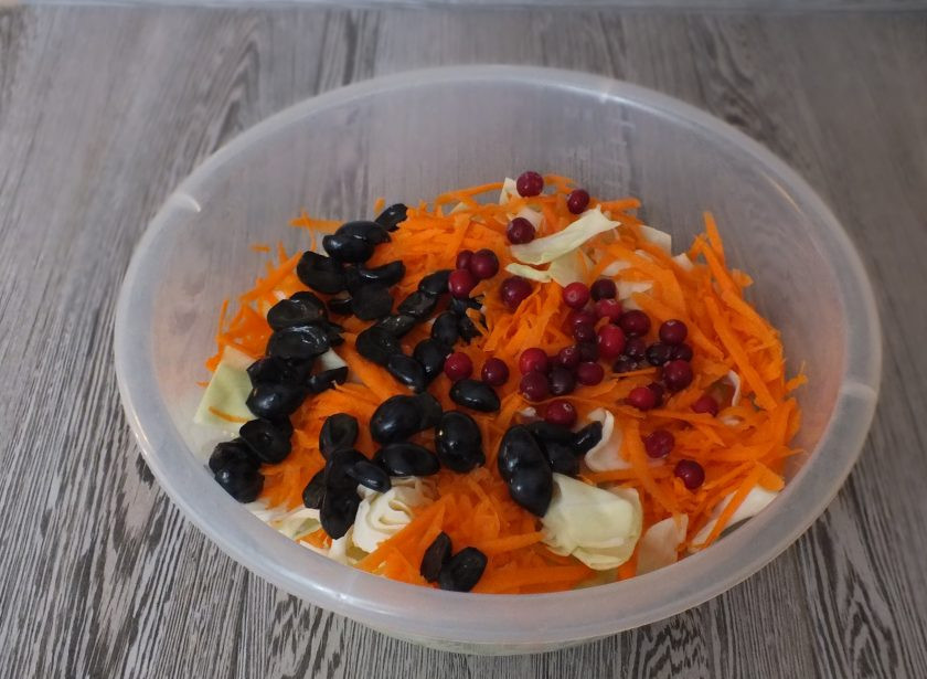 1. Этап. Капуста Провансаль с виноградом и яблоками: Морковь натрите на крупной терке. Виноград разрежьте пополам и удалите косточки. Переложите в чашу с капустой, добавьте клюкву.