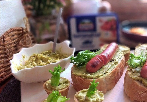 1. Этап. Паштет из горошка и творожного сыра: Сверху выкладываем румяные сосиски. Дополняем бутерброд листиками салата.