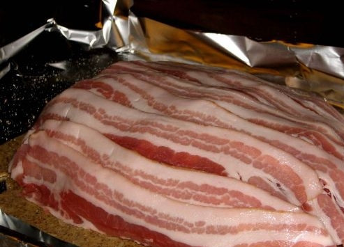 1. Этап. Рыбный пирог Калакукко: Беконом закрываем полностью всю рыбу. Сверху бекон посыпаем солью и перцем по вкусу.