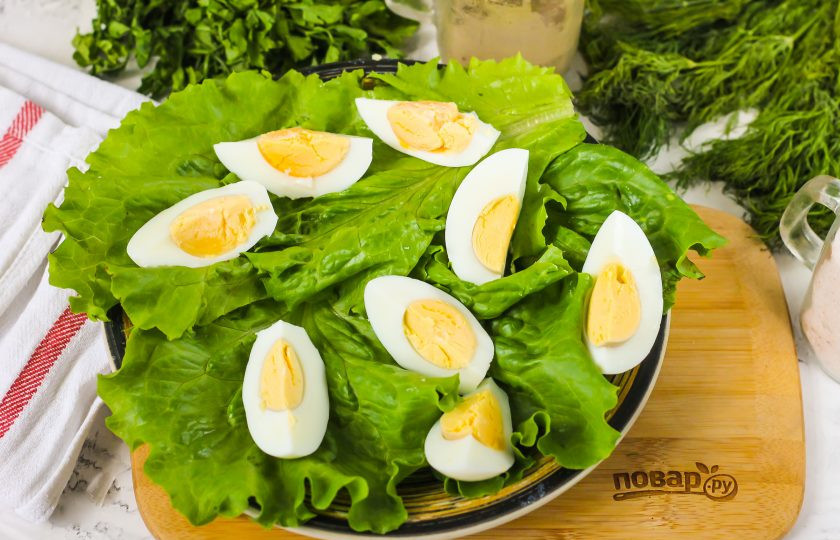 1. Этап. Салат с красной рыбой и грейпфрутом: Очистите куриные яйца от скорлупы, промойте их в воде и нарежьте четвертинками. Выложите на листья салата.