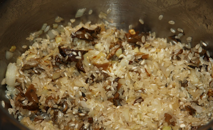 1. Этап. Ризотто с сушеными белыми грибами: Грибы отварите 10 минут в той же воде, в которой их замачивали. Сливаем воду и ставим в сторону. Грибы отжимаем и мелко нарезаем. На растительном масле обжариваем измельченный лук, добавляем грибы и рис. Обжариваем еще 5 минут, до прозрачности риса.