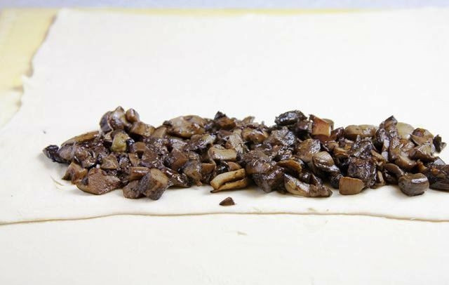 1. Этап. Веллингтон: Тесто раскатываем в достаточно тонкий пласт. В центр теста выкладываем грибную начинку. В центре теста оставляем нетронутой площадь для фарша, а всю остальную площадь нарезаем полосками шириной примерно в 1,5 см. Для наглядности смотрите фото.