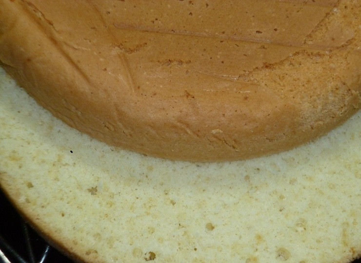 1. Этап. Торт Чародейка по ГОСТу: Перелейте тесто в форму для выпечки и отправьте в духовку на 30 минут при 180 градусах. Бисквит остудите, затем разрежьте на 2 коржа. Воду смешайте с сахаром для пропитки. Промажьте смесью бисквиты.