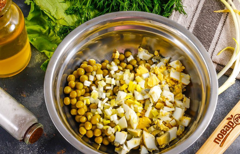 1. Этап. Начинки для мексиканских лепешек: Отварные куриные яйца нарежьте мелкими кубиками, высыпьте нарезку в глубокую емкость. Добавьте туда же консервированный горошек, слив с него маринад. Промойте и измельчите стебли зеленого лука. Добавьте щепотку соли, майонез и перемешайте начинку.