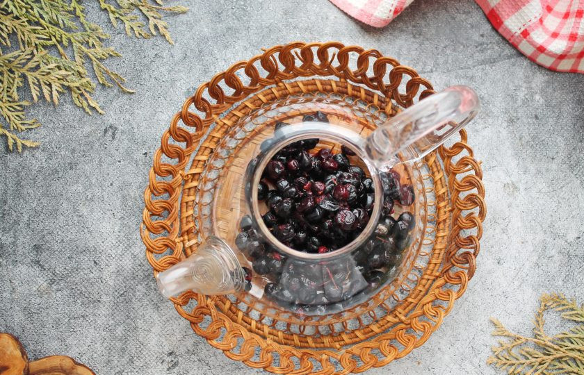 1. Этап. Чай из черноплодной рябины: Половину ягод черноплодки раздавите толкушкой. Чайник ошпарьте кипятком и выложите целые и мятые ягоды черноплодной рябины.