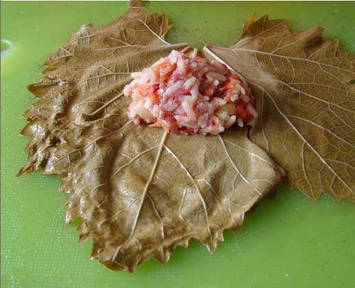 1. Stage. Dolma: Lay the grape leaves on the table with the smooth side down and the distinct veins up. Put some minced meat in the middle of each sheet.