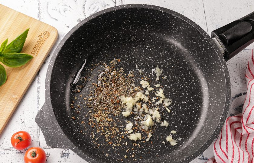 1. Этап. Пицца Нью-йорк: В сотейник или в сковороду налейте 1 ст.л. растительного масла. Добавьте измельченный чеснок, орегано и базилик, можно добавить молотый перец чили и щепотку соли. Жарьте на среднем огне, постоянно помешивая, 1-2 минуты.