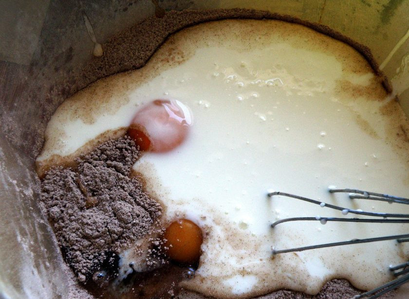 1. Этап. Пирог «ТвороШок»: Включите духовку на разогрев до 200 градусов. В просторную миску разбейте два яйца, добавьте один белок, отложив желток в заливку. Всыпьте сахар, влейте кефир, добавьте просеянную с какао и разрыхлителем муку. Миксером на низких оборотах быстро смешайте тесто до однородности.