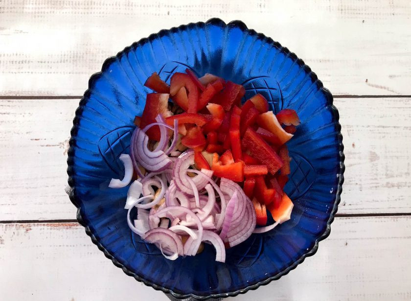 1. Этап. Салат с мидиями и стручковой фасолью: Красный лук очистите от шелухи, нарежьте полукольцами и выложите в тарелку.