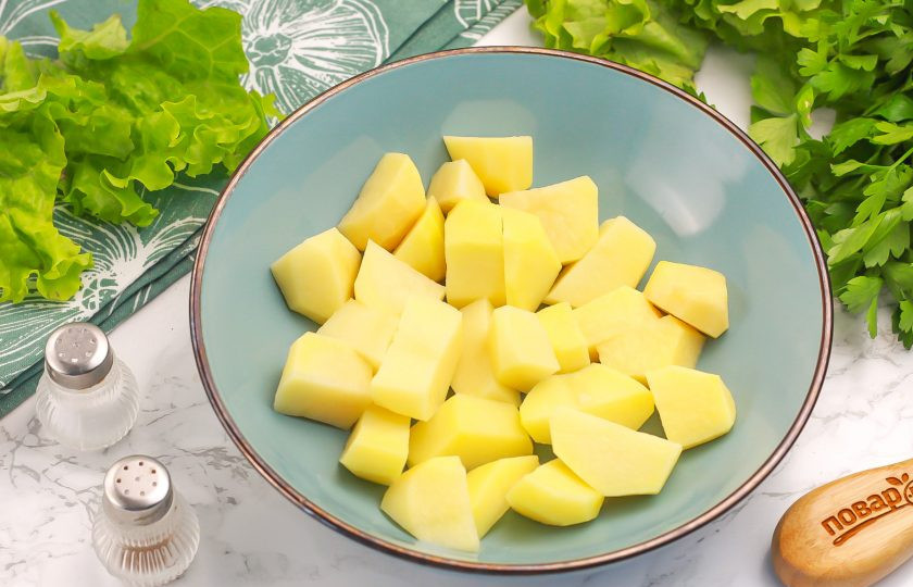 1. Этап. Перец в духовке запеченный с картофелем: Нарежьте картофель средним кубиком и высыпьте нарезку в глубокую емкость.