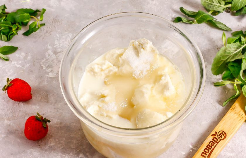 1. Этап. Клубничный чизкейк с творогом без выпечки: В глубокую емкость выложите творог, влейте сливки и жидкость с желатином, всыпьте 100 грамм сахарного песка. Норму сахара не уменьшайте, так как желатин немного 