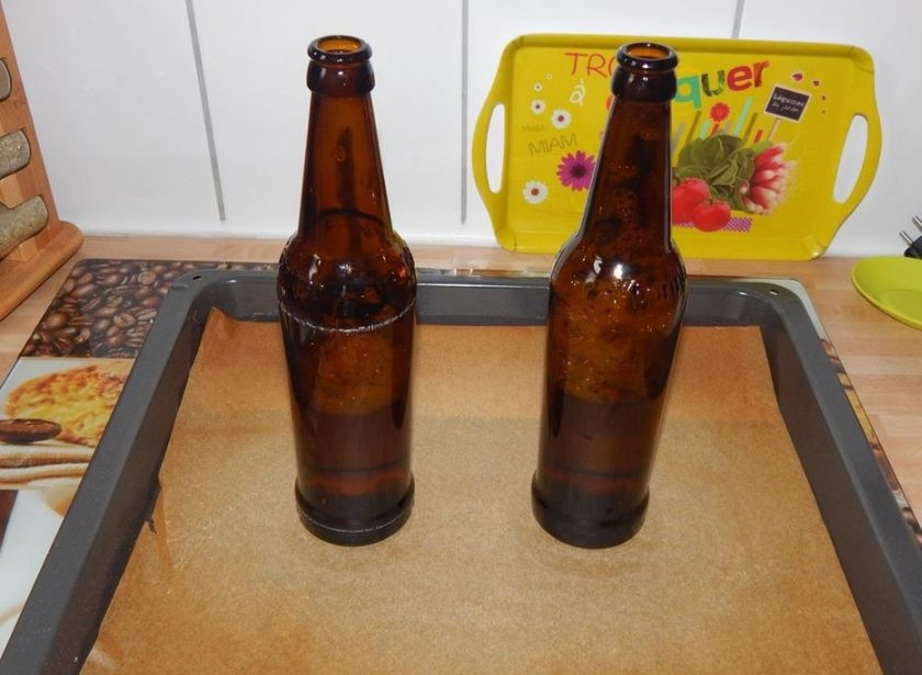 1. Этап. Курица на бутылке в духовке: Из каждой бутылки пива слейте по 1 стакану пенного напитка, а остальное оставьте для рецепта. Поставьте бутылки на противень с пергаментом.