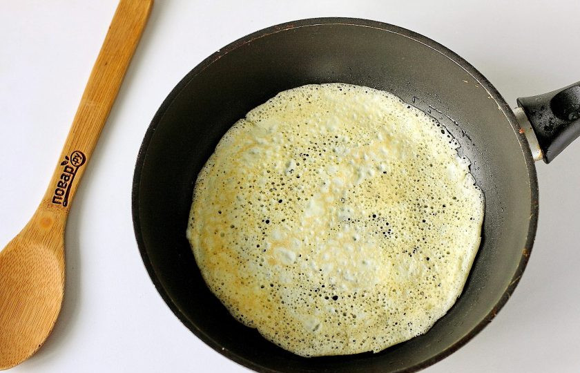 1. Этап. Блинный салат: Сковороду смажьте маслом и вылейте часть яичной массы, распределяя ее по кругу. Испеките блинчик. Долго обжаривать его не нужно, как только блин схватится, сразу переворачивайте его.