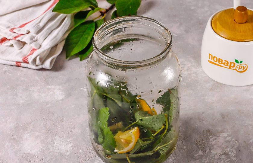 1. Этап. Компот из листьев вишни на зиму: Выложите в чистую банку и добавьте нарезанную четверть лимона или апельсина, удалив косточки из цитрусового, если они попадались.