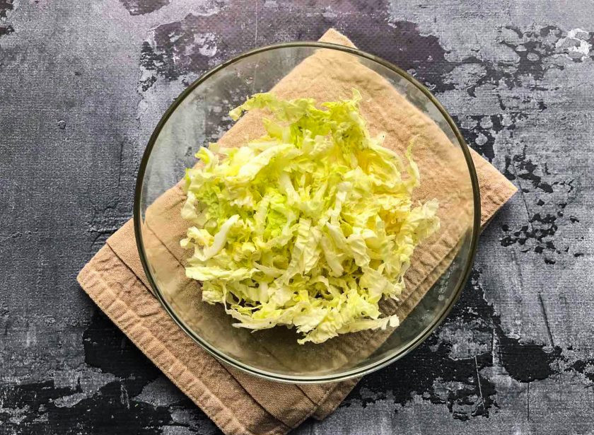 1. Этап. Салат с пекинской капустой и мидиями: Пекинскую капусту нарежьте и выложите в глубокую тарелку.