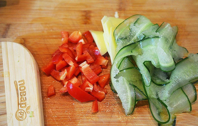 1. Этап. Теплый салат из говядины: 6. Нарежьте сладкий перец очень маленькими кубиками, огурцы – тонкими лентами, сельдерей – очень тонкими дольками.