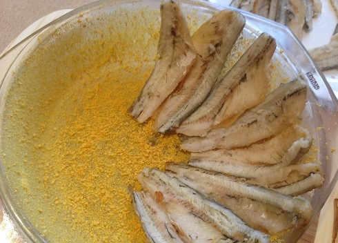 1. Этап. Запеканка с корюшкой: 4. Форму для выпечки смазываем сливочным маслом и щедро посыпаем панировочными сухарями. А затем выкладываем филе рыбки.