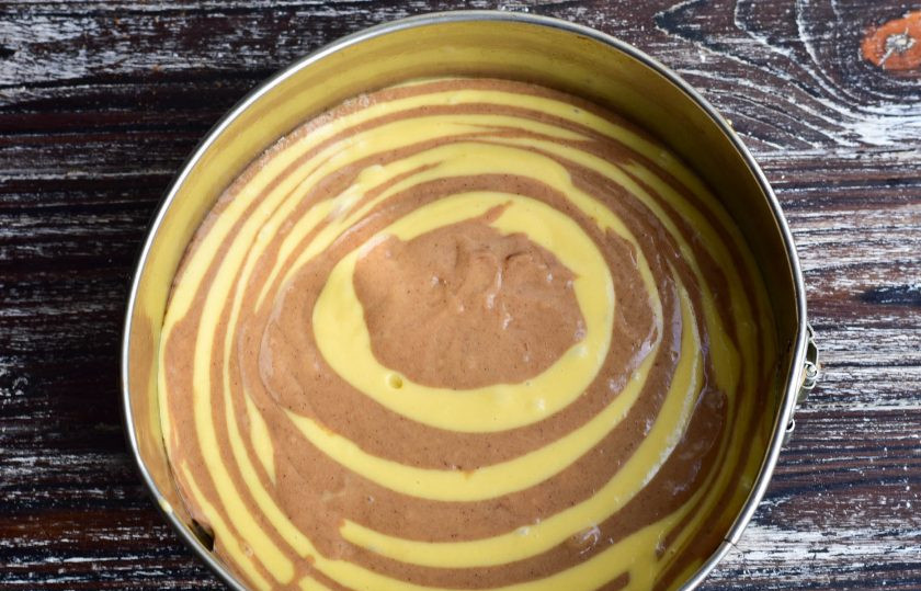 1. Этап. Пирог Зебра на молоке: Форму для выпекания застелите пергаментной бумагой, бока смажьте растительным маслом. Теперь налейте 1 ст. ложку светлого теста, затем темного. Повторите действия до тех пор, пока тесто не закончится.