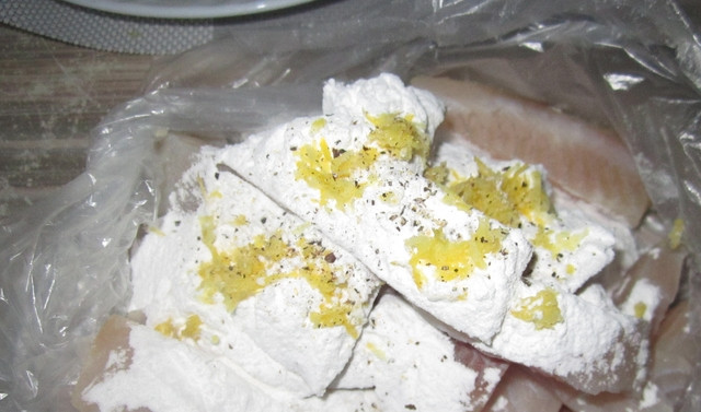 1. Этап. Камбала, жаренная во фритюре: Рыбное филе разделываем на брусочки по 3 сантиметра шириной (для удобства). Сбрызгиваем лимонным соком, солим и перчим (я еще потерла немного лимонной цедры). Даем постоять минут 10. Затем выкладываем в пакет. В пакет также необходимо добавить крахмал, хорошенько потрясите, чтобы рыба вся им покрылась.