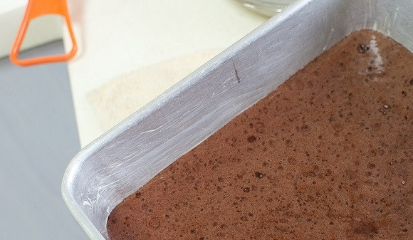 1. Этап. Простой шоколадный бисквит: 10. Добавьте масло с какао в тесто, перемешайте лопаткой. Форму для выпекания смажьте сливочным маслом и вылейте в нее тесто.