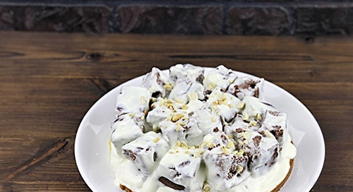 1. Этап. Торт Графские развалины со сметаной: Кусочки шоколадного коржа опускаем в крем и выкладываем поверх светлого коржа. Присыпаем все орехами.