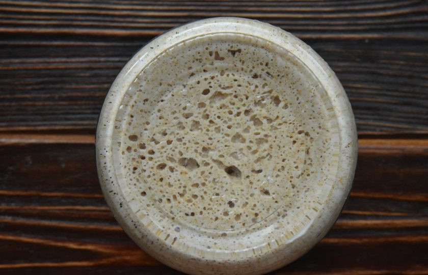 1. Этап. Цельнозерновой хлеб на закваске в хлебопечке: Перед приготовлением теста заранее подготовьте опару. Лучше это сделать с вечера, а на утро заняться приготовлением теста. Смешайте 25 граммов пшеничного стартера с 25 мл. воды и 25 граммами цельнозерновой муки. Накройте емкость с опарой и постаьте в холодильник. За 8-12 часов (в зависимости от температуры в холодильнике) опара достигнет своего пика зрелости.