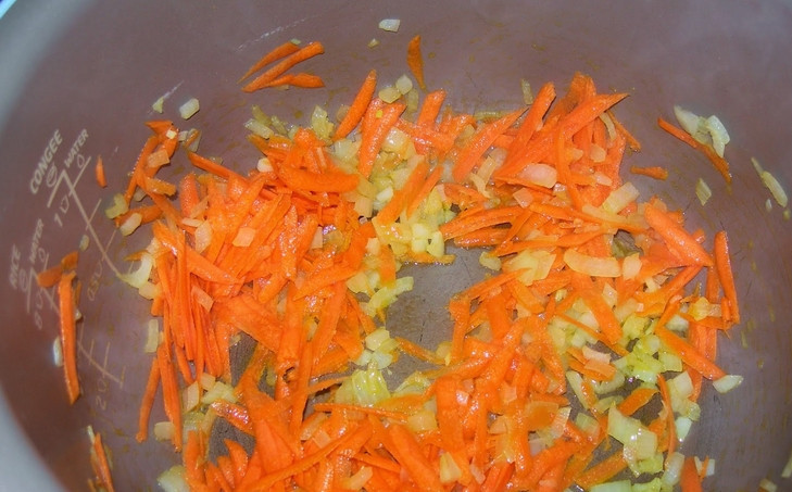 1. Этап. Щи из индейки: Натрите на терке морковь, а лук измельчите. Влейте в чашу мультиварки немного масла. Обжарьте на нем овощи 5 минут. Режим 