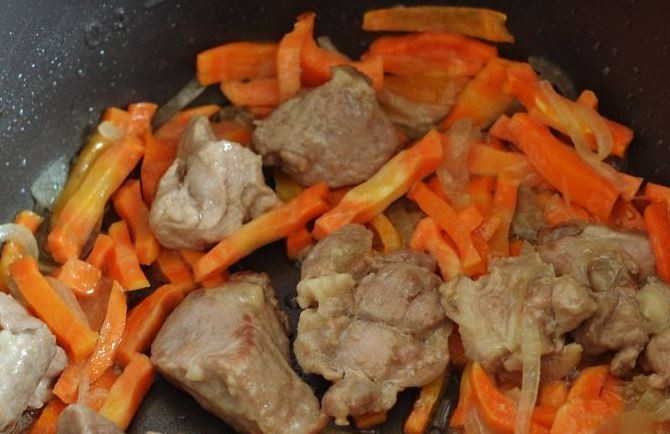 1. Этап. Тушеный картофель со свининой: Очистите лук и морковь, вымойте овощи. Нарежьте лук полукольцами, а морковь нашинкуйте соломкой. В чашу мультиварки влейте растительное масло, обжарьте на нем овощи и свинину до золотистого цвета.