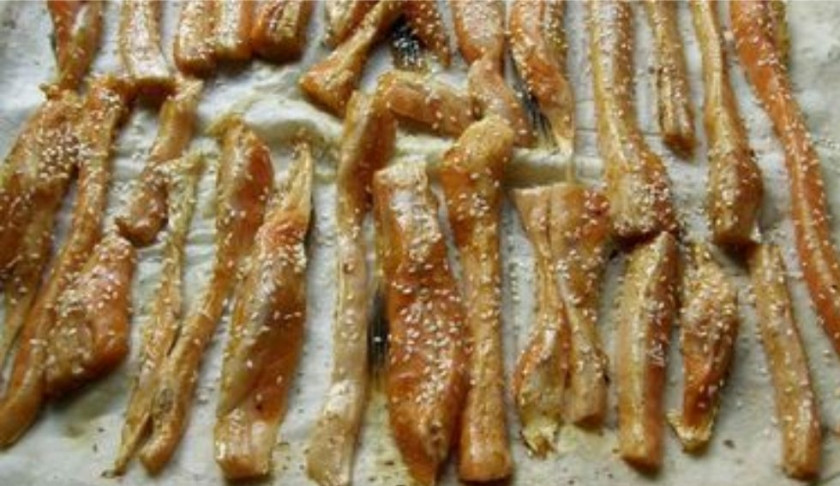 1. Этап. Брюшки семги в духовке: 2. Три листа лаваша выложите на смазанный маслом противень, а сверху добавьте кусочки семги. Приправьте специями, солью и кунжутом.