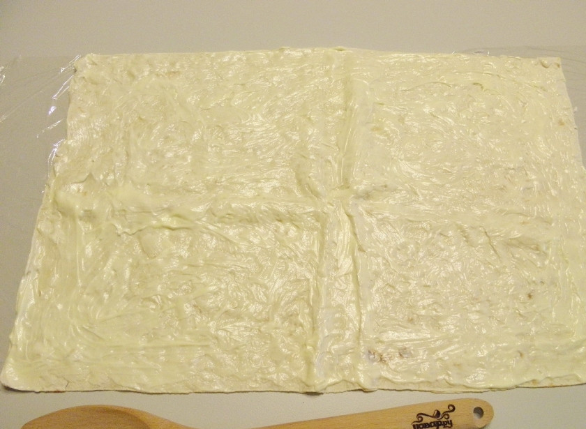 1. Этап. Новогодний рулет из лаваша: Стол застелите пищевой пленкой. Расстелите лаваш, смажьте его хорошо майонезом.