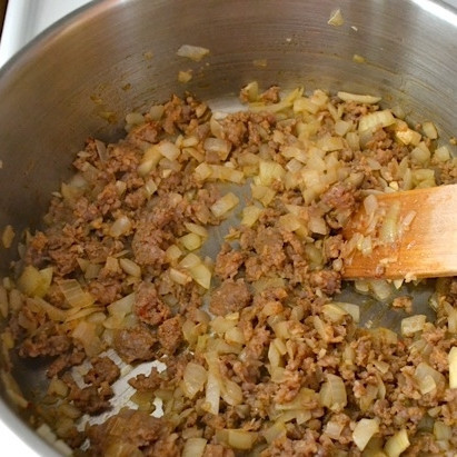 1. Этап. Запеченные спагетти с сосисками: Сосиски нарезаем мелкими кубиками и добавляем к луку и чесноку. Помешивая, обжариваем 3-5 минут до готовности сосисок.